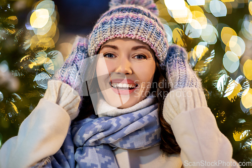 Image of portrait of happy young woman in christmas lights