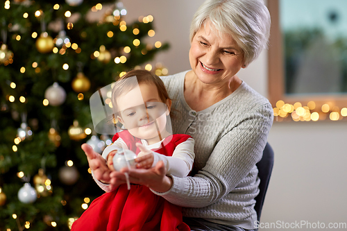 Image of grandmother and baby girl with at christmas tree