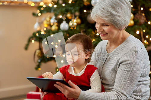 Image of grandmother and baby girl with christmas gifts