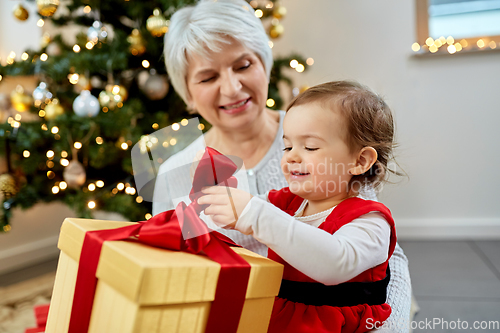 Image of grandmother and baby girl with christmas gift