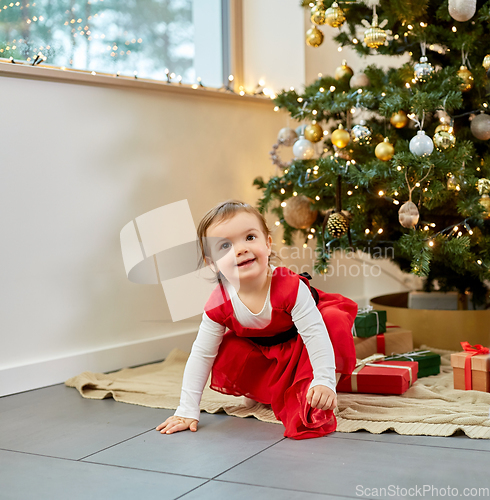 Image of happy baby girl with christmas gifts at home