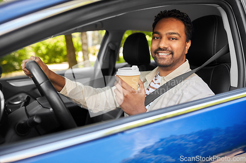 Image of happy indian man or driver with coffee driving car
