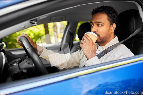 Image of tired indian man or driver with coffee driving car