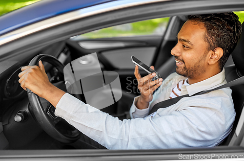 Image of man driving car and recording voice by smartphone