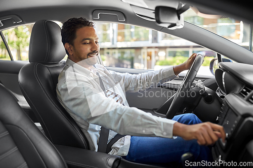 Image of smiling indian man or driver driving car