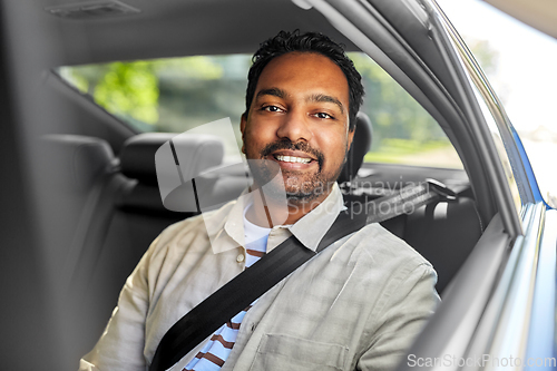 Image of smiling indian male passenger in taxi car