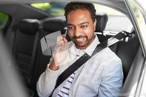 Image of male passenger calling on smartphone in taxi car