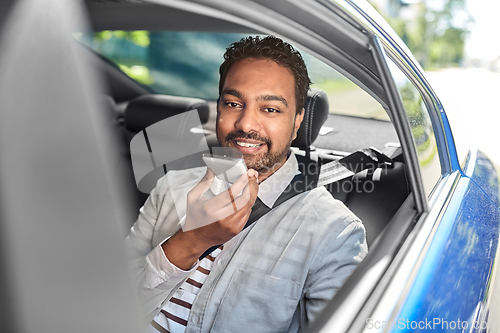 Image of male passenger calling on smartphone in taxi car