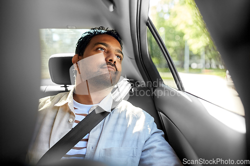 Image of dreaming indian male passenger in taxi car