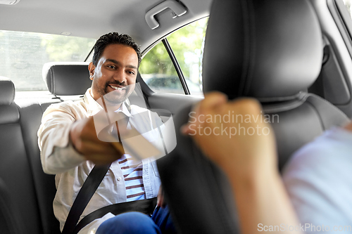 Image of indian man giving credit card to taxi car driver