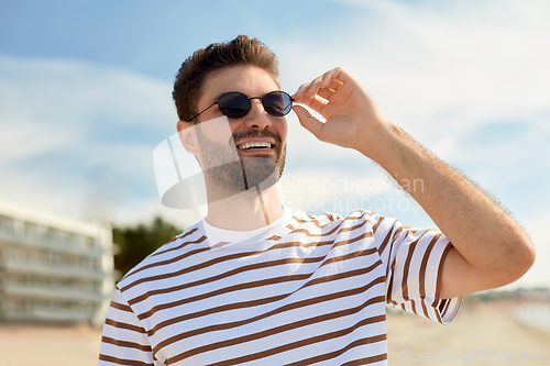 Image of young man in sunglasses on summer beach