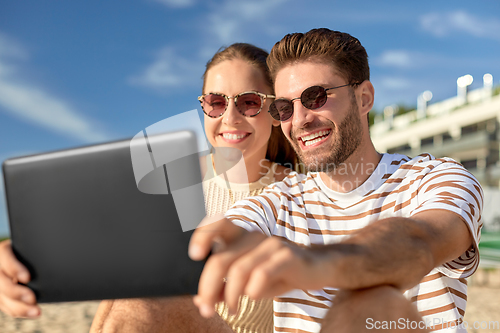 Image of happy couple with tablet pc at on summer beach
