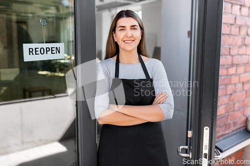 Image of happy woman with reopen banner on door glass