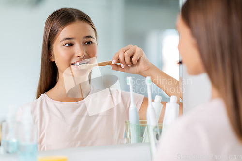 Image of teenage girl with toothbrush brushing teeth