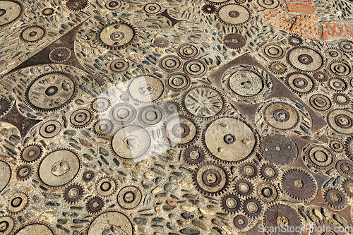 Image of Unusual floor with pattern from pebbles, brick and rusty metal d