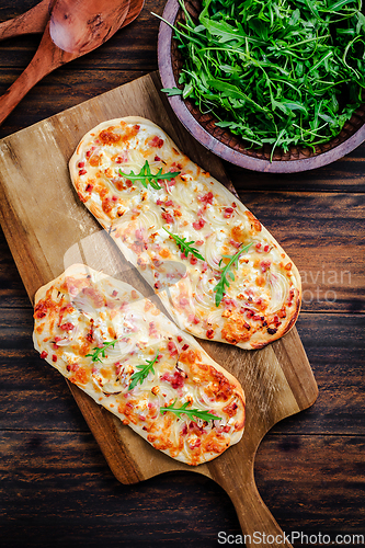 Image of French tarte flambee with cream cheese, bacon and onions. Flammkuchen from Alsace region