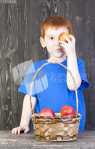 Image of red-haired boy playing with mature nectarines