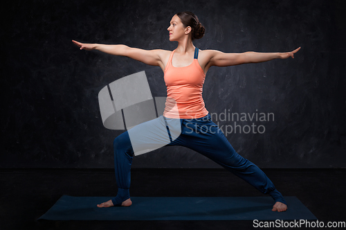 Image of Woman practices yoga asana utthita Virabhadrasana