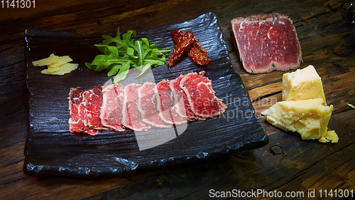 Image of Barbecue wagyu roast beef sliced as top view on a metal tray with copy space right