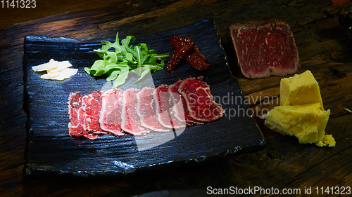 Image of Barbecue wagyu roast beef sliced as top view on a metal tray with copy space right