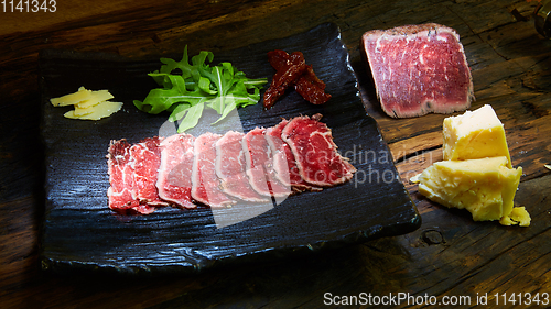 Image of Barbecue wagyu roast beef sliced as top view on a metal tray with copy space right