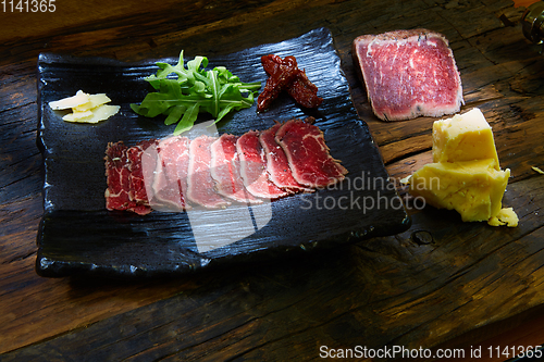 Image of Barbecue wagyu roast beef sliced as top view on a metal tray with copy space right