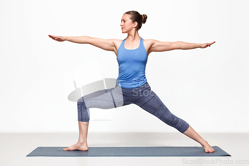 Image of Woman practices yoga asana utthita Virabhadras