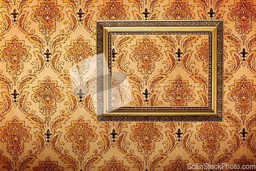 Image of Vintage gold plated picture frame on retro wallpaper