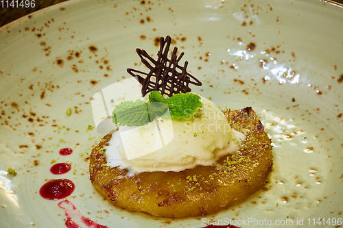 Image of Grilled pineapple with scoops of vanilla ice cream.