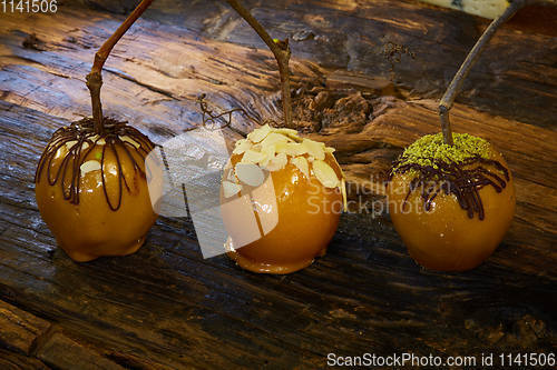 Image of Homemade Caramel Apples on a Stick for Halloween. Organic Snack - Caramel Apples with Walnuts.