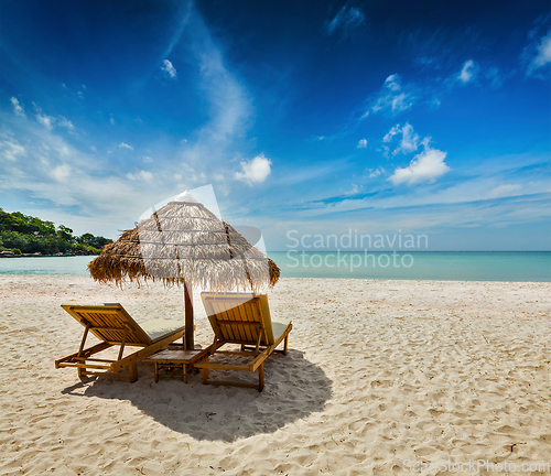 Image of Two beach lounge chairs under tent