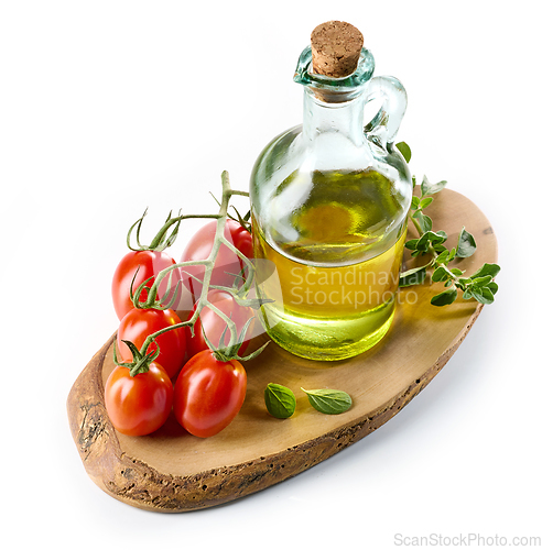 Image of olive oil and tomatoes on wooden cutting board