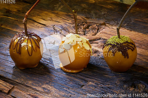 Image of Homemade Caramel Apples on a Stick for Halloween. Organic Snack - Caramel Apples with Walnuts.