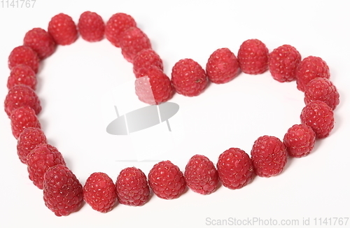 Image of Heart made out of raspberries over white background