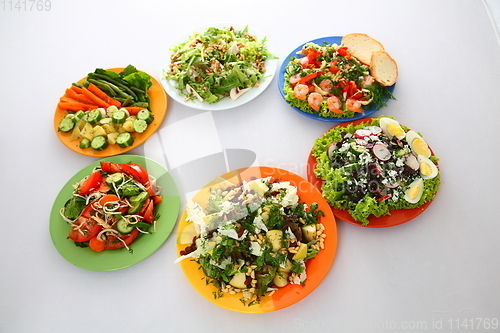 Image of set with different salads on white background