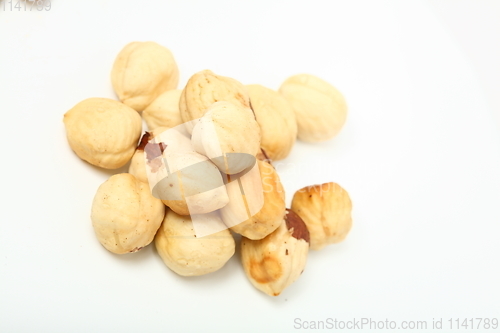 Image of The handful of organic shelled hazelnuts on white background. Shallow dof.