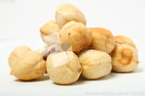 Image of The handful of organic shelled hazelnuts on white background. Shallow dof.