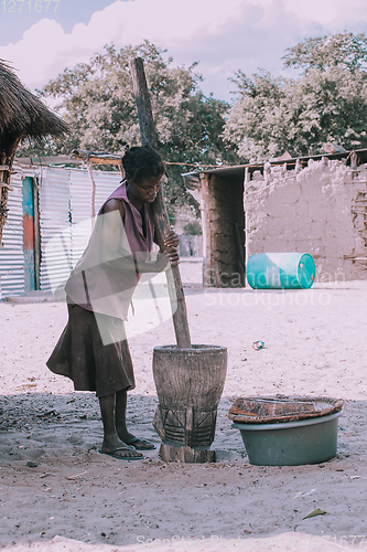 Image of woman crushing the millet, Africa, Namibia