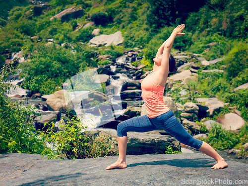 Image of Woman doing Ashtanga Vinyasa Yoga asana Virabhadrasana 1 Warrior