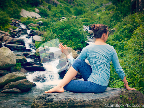 Image of Woman doing Ardha matsyendrasana asana outdoors