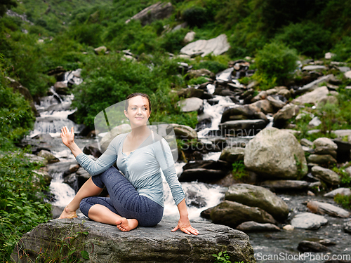 Image of Woman doing Ardha matsyendrasana asana outdoors