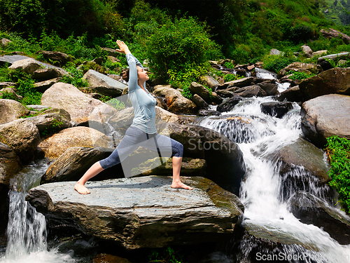 Image of Woman doing Ashtanga Vinyasa Yoga asana Virabhadrasana 1 Warrior