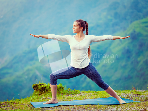 Image of Woman doing Ashtanga Vinyasa Yoga asana Virabhadrasana 2 Warrior