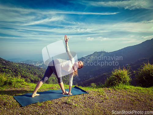 Image of Woman doing Ashtanga Vinyasa yoga asana Parivrtta trikonasana