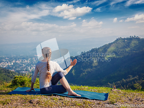 Image of Woman practices yoga asana outdoors