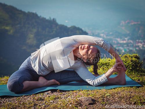 Image of Young sporty fit woman doing Hatha Yoga asana