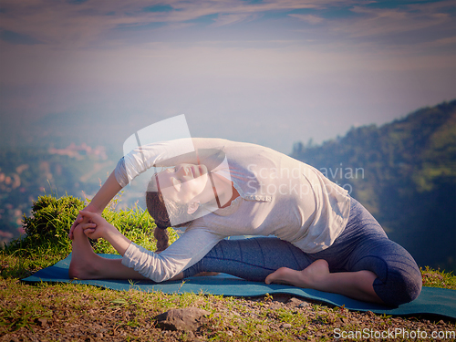 Image of Young sporty fit woman doing Hatha Yoga asana