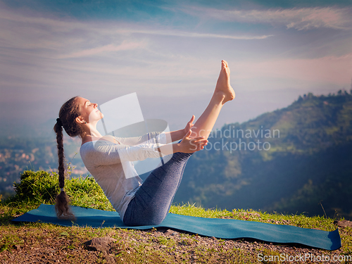 Image of Woman doing Ashtanga Vinyasa Yoga asana Navasana - boat pose