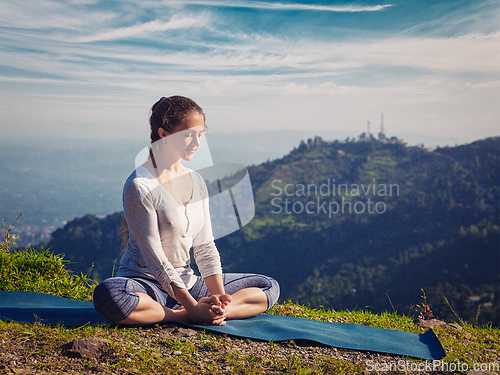 Image of Sporty fit woman practices yoga asana Baddha Konasana outdoors