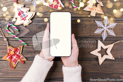 Image of Close up woman holding phone with empty white screen mockup near